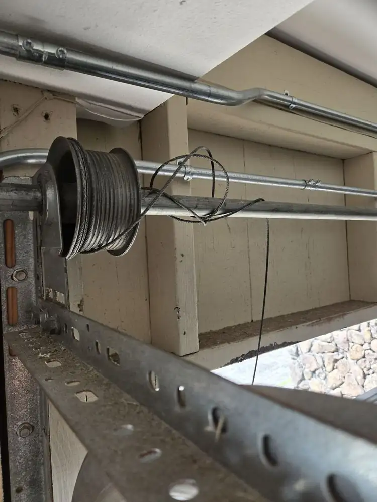 Cable drum and track above a garage door