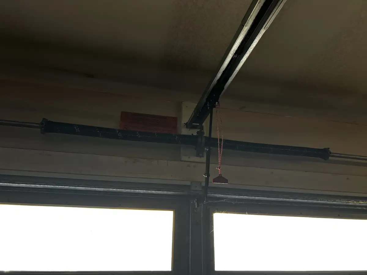 Broken torsion spring on the bar above garage door windows