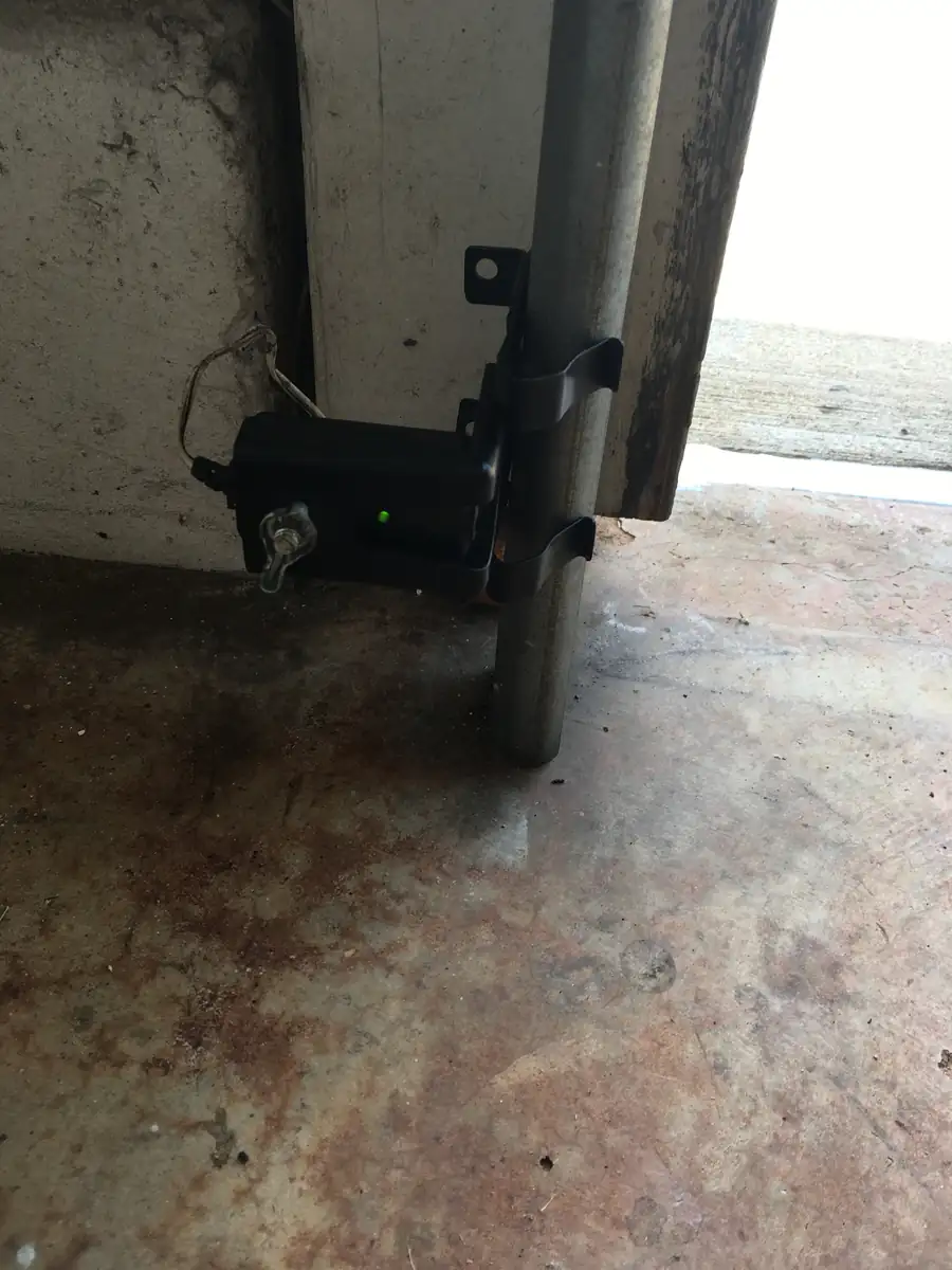 Garage door safety sensor mounted on the door track